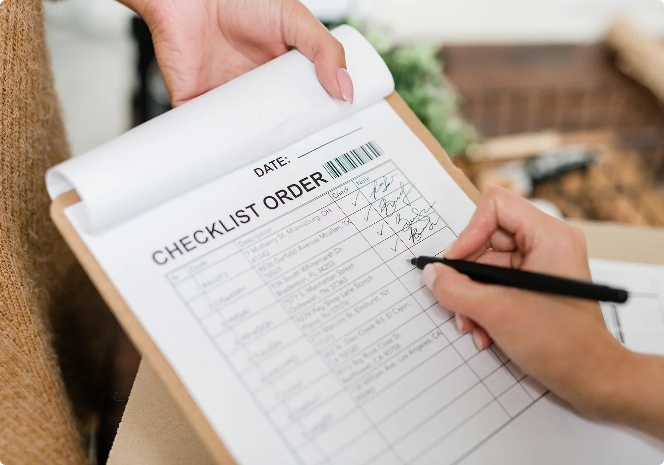 hand ticking off a checklist order form on a clipboard